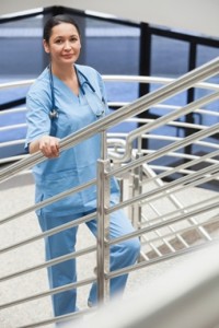 Smiling nurse in a stairwell leaning on the railings